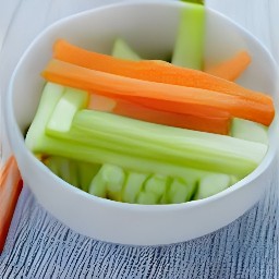 there a bowl of zucchini, carrots and celery sticks.