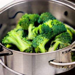 8 cups of water in a steamer pot with broccoli florets that have been cooked for 6 minutes.
