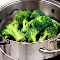 8 cups of water in a steamer pot with broccoli florets that have been cooked for 6 minutes.