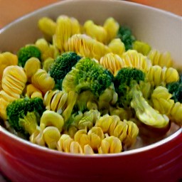 a bowl of pasta with broccoli, pesto, black pepper, and salt.