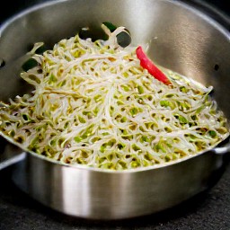 a dressing made from shredded lime leaves, rice vinegar, soy sauce, chopped lemon grass, chopped spring onion, red chili pepper slices, mung bean sprouts and powdered sugar.