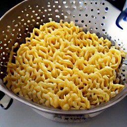 the cooked egg noodles are drained in a colander.