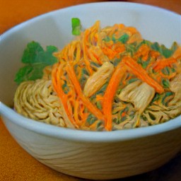 the dressing is poured into the large bowl, then the fried veggie and tofu cubes are added. the chopped coriander is scattered over the large bowl and stirred with a wooden spoon for 2 minutes.